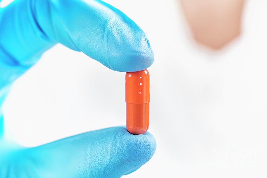 Scientist Holding Orange Pill #1 Photograph by Microgen Images/science Photo Library