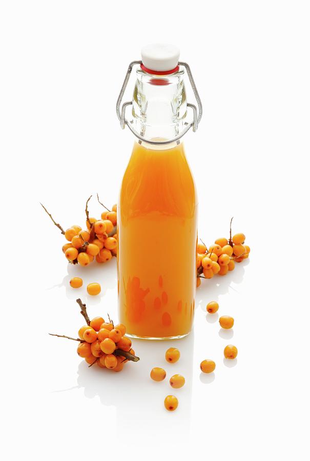 Sea Buckthorn Juice In A Stoppered Bottle #1 Photograph by Petr Gross