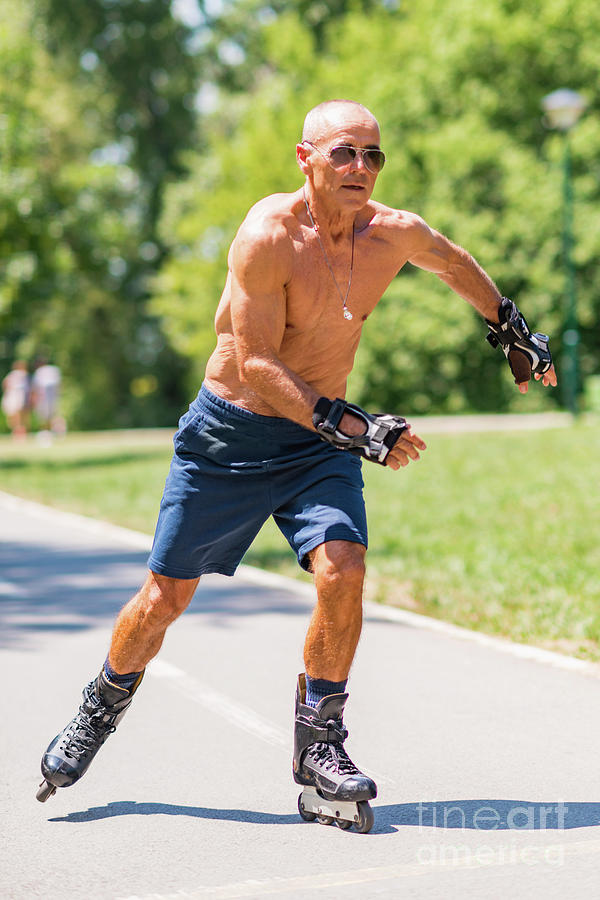 Summer Photograph - Senior Man Roller Skating In Park #1 by Microgen Images/science Photo Library
