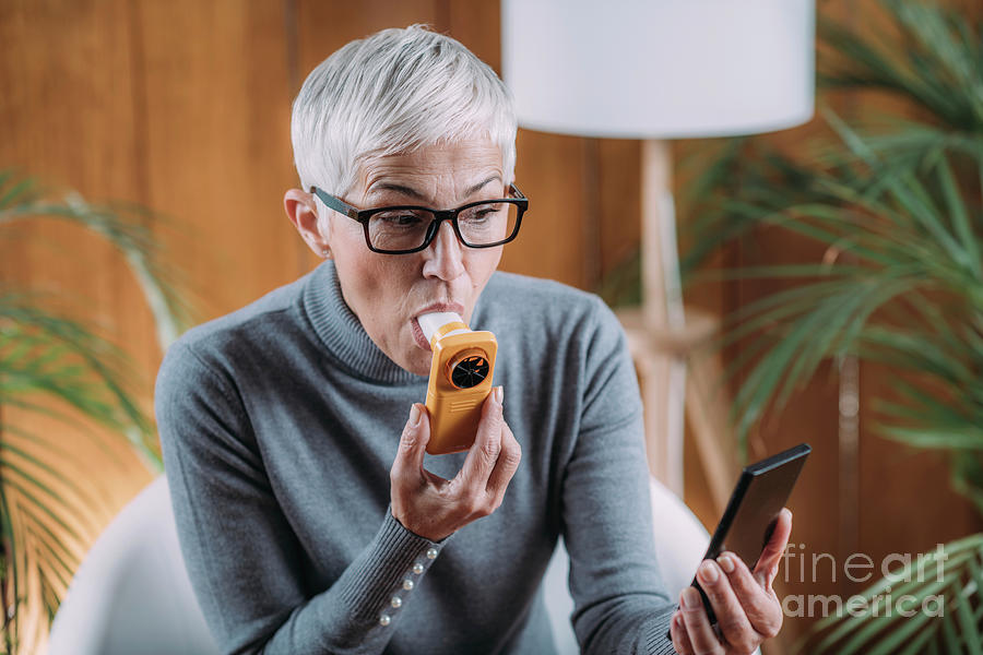 Senior Woman Using Spirometer At Home Photograph by Microgen Images ...