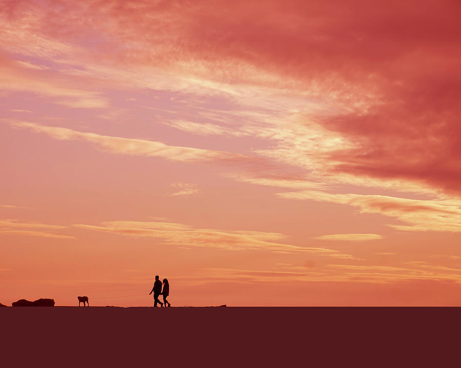 Silhouette of beach walkers at sunset #1 Photograph by Steve Estvanik