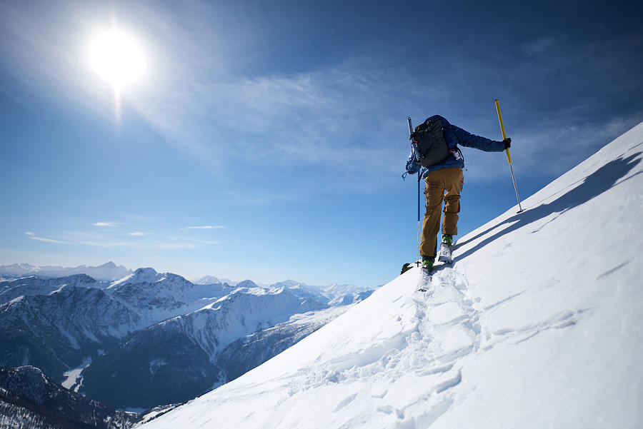 Ski Touring Uphill With A Mountain Backdrop Photograph by Cavan Images ...