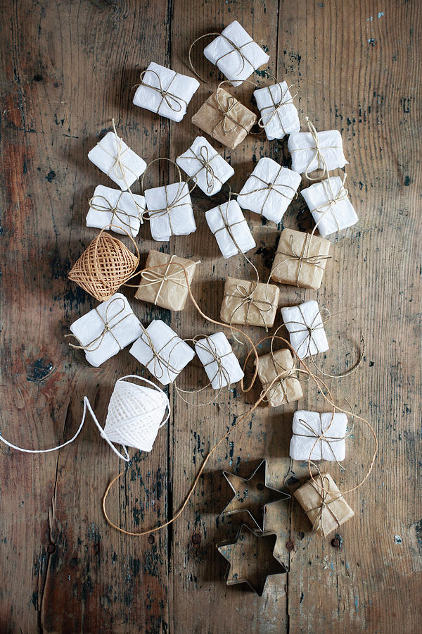 Small Gifts Wrapped In White And Pale Brown And Star-shaped Pastry Cutters #1 Photograph by Alicja Koll