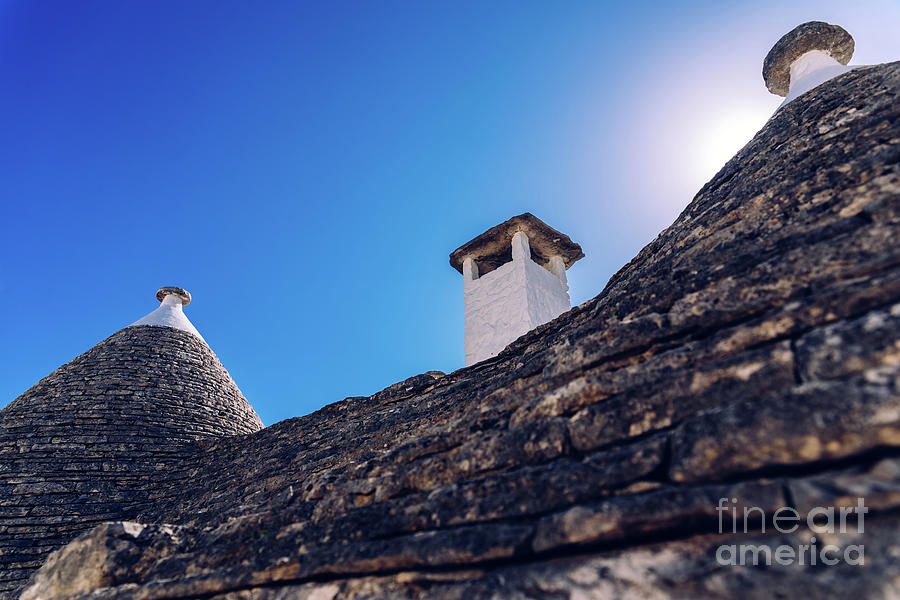 Stone tiles cover the roofs of the trulli in Alberobello, an Italian city to visit on a trip to Italy. #1 Photograph by Joaquin Corbalan