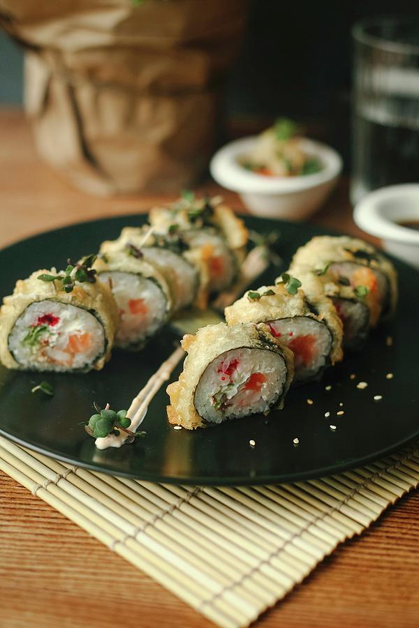Sushi Rolls With Salmon, Deep Fried In Tempura Batter, On A Black Plate #1 Photograph by Kuzmin5d
