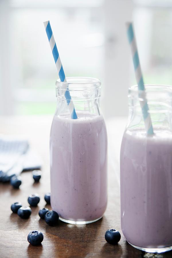 Two Bottles Of Blueberry And Banana Smoothie With Straws #1 Photograph by Victoria Firmston