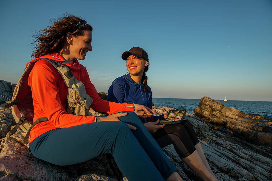 Portland Photograph - Two Women Looking At Their Fly Selection While Fly Fishing On Teh Coast Of Maine. #1 by Cavan Images