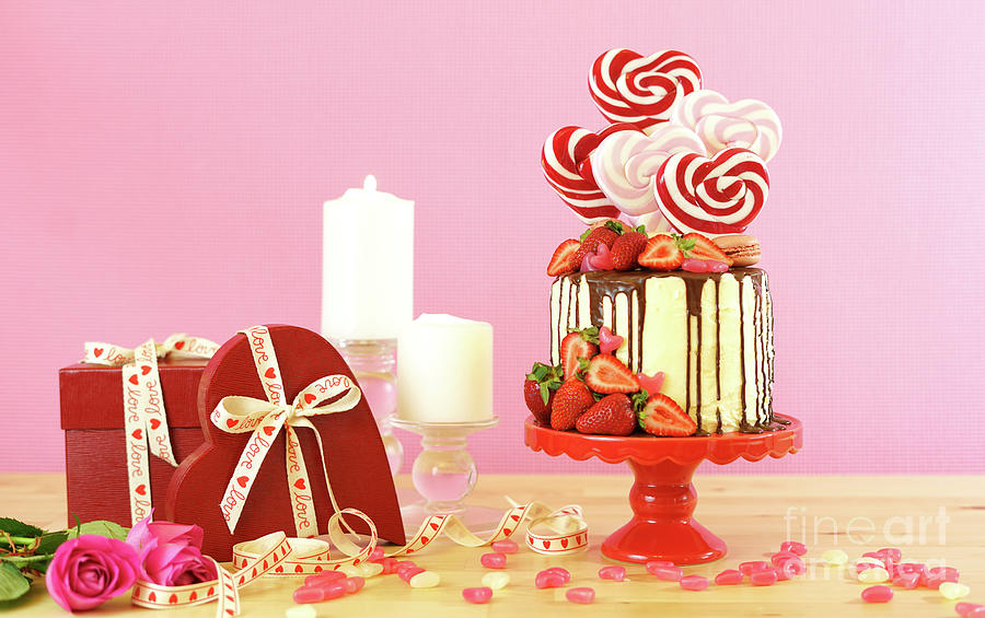 Valentines Day candyland drip cake decorated with heart shaped lollipops. #1 Photograph by Milleflore Images