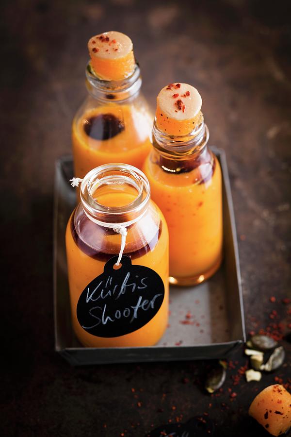 Vegan Pumpkin Shots With Chilli Flakes In Small Glass Bottles #1 Photograph by Eising Studio