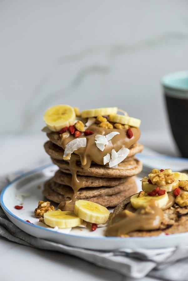 Vegan Spelt Pancakes With Bananas, Goji Berries And Coconut #1 Photograph by Hein Van Tonder