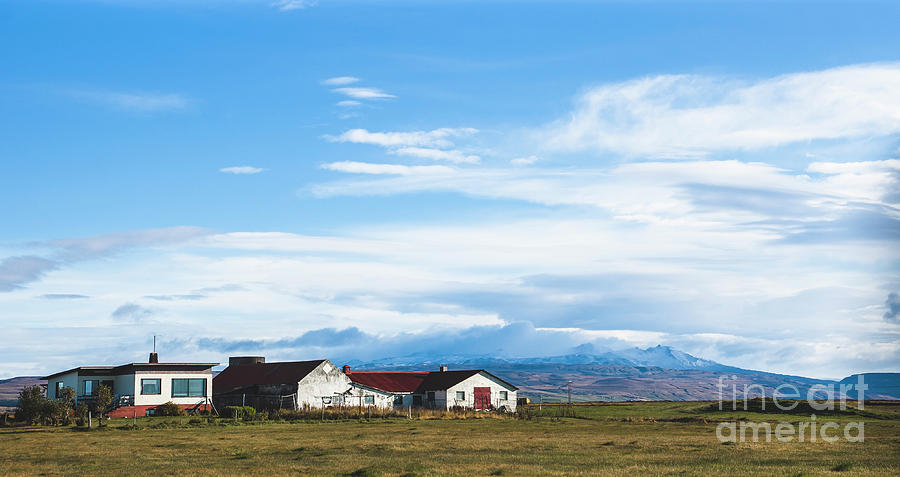 Village with farms in a rural area of the mountains of Iceland, with snowy mountains in the background. #1 Photograph by Joaquin Corbalan
