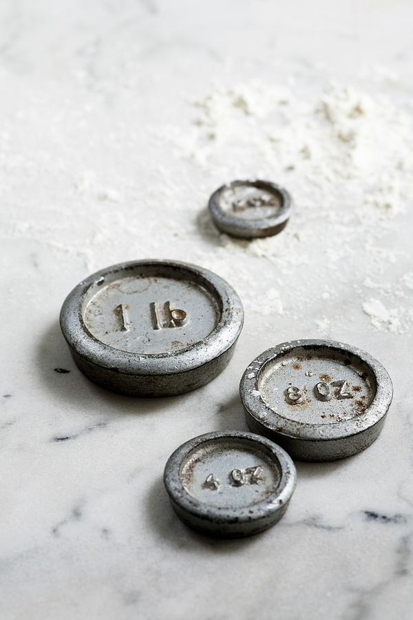 Weights On A Floured Marble Surface #1 Photograph by Victoria Firmston