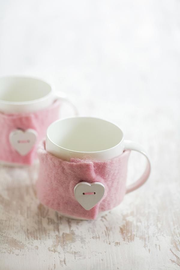 White Mugs With Hand-made Pink Mug Cosies Decorated With Heart-shaped Buttons #1 Photograph by Alicja Koll