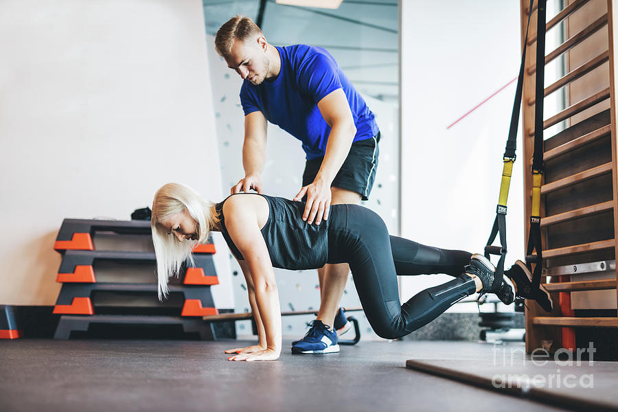 Woman exercising with personal trainer at the gym. #1 Photograph by Michal Bednarek
