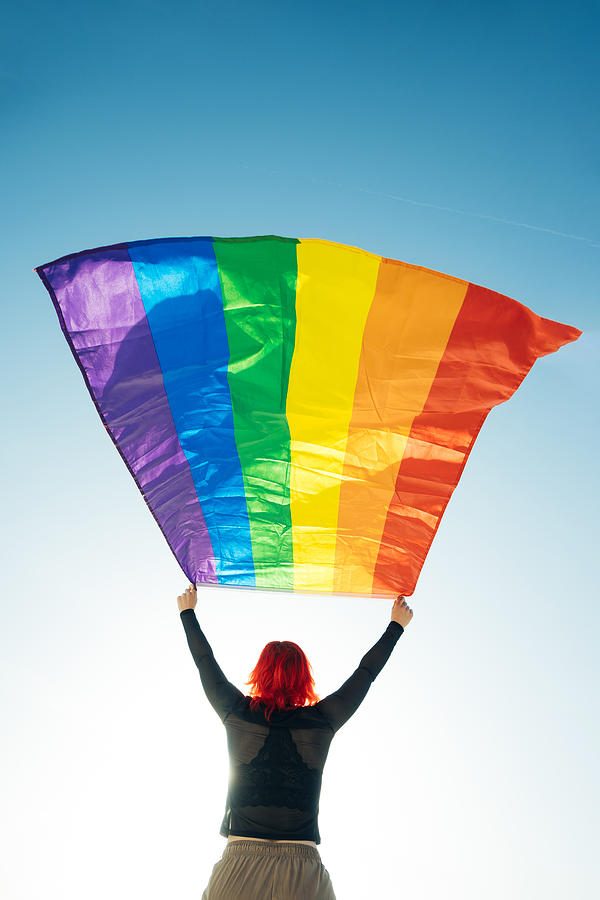 Woman Holding The Gay Rainbow Flag On Blue Sky Background. Happiness,  Freedom And Love Concept For Same Sex Couples. Photograph by Cavan Images -  Pixels