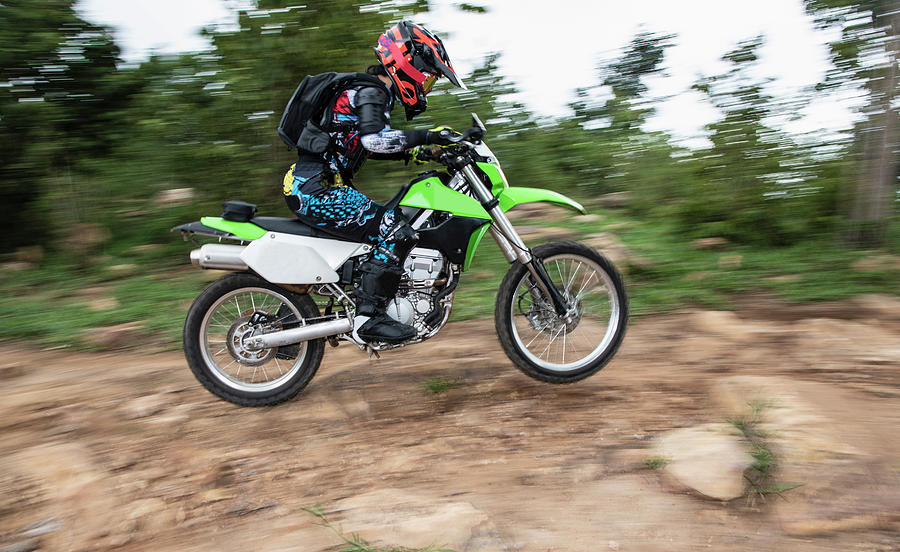 Woman On Off Road Bike Racing Up A Hill On A Rough Trail Photograph by Cavan Images - Fine Art 