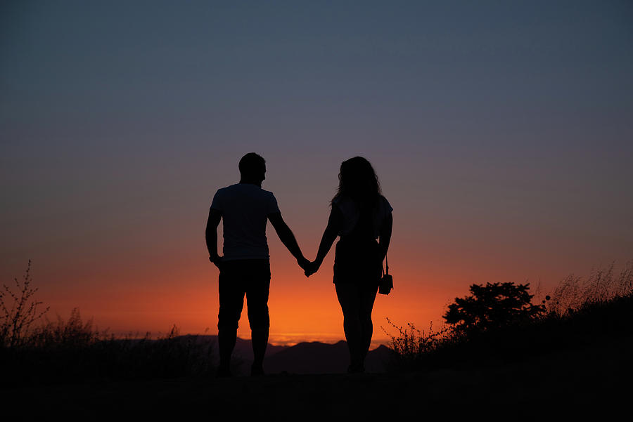 Young Couple Enjoying Sunset In The Mountains Photograph by Cavan ...