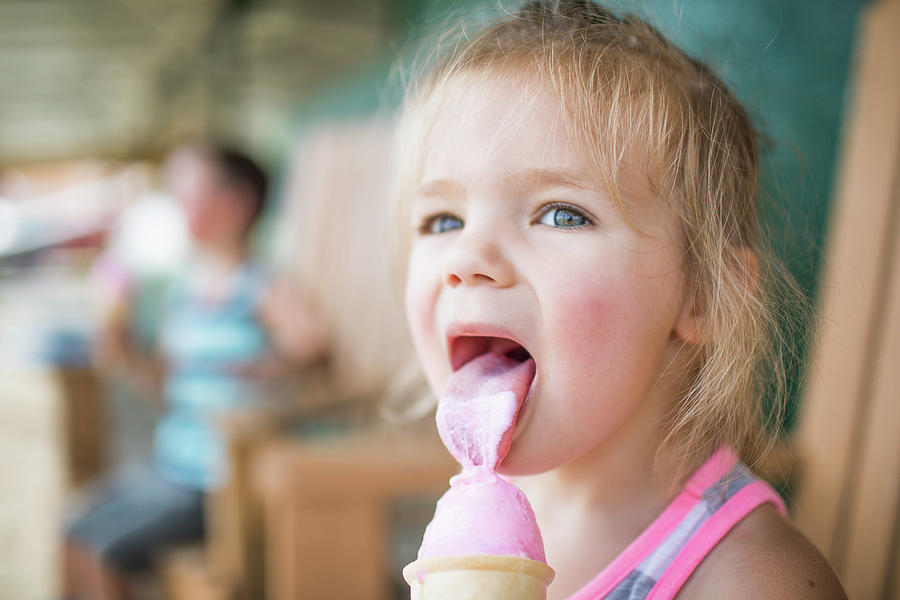 Young Cute Girl Happily Licking Pink Ice Cream On Summer Day