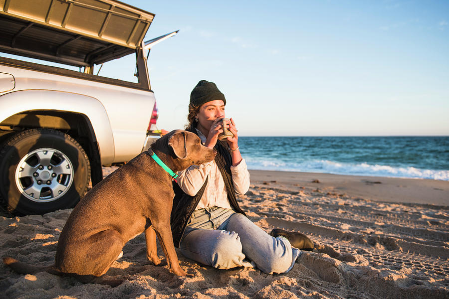 Young Woman Enjoying Drink In Mug While Beach Car Camping With Dog ...