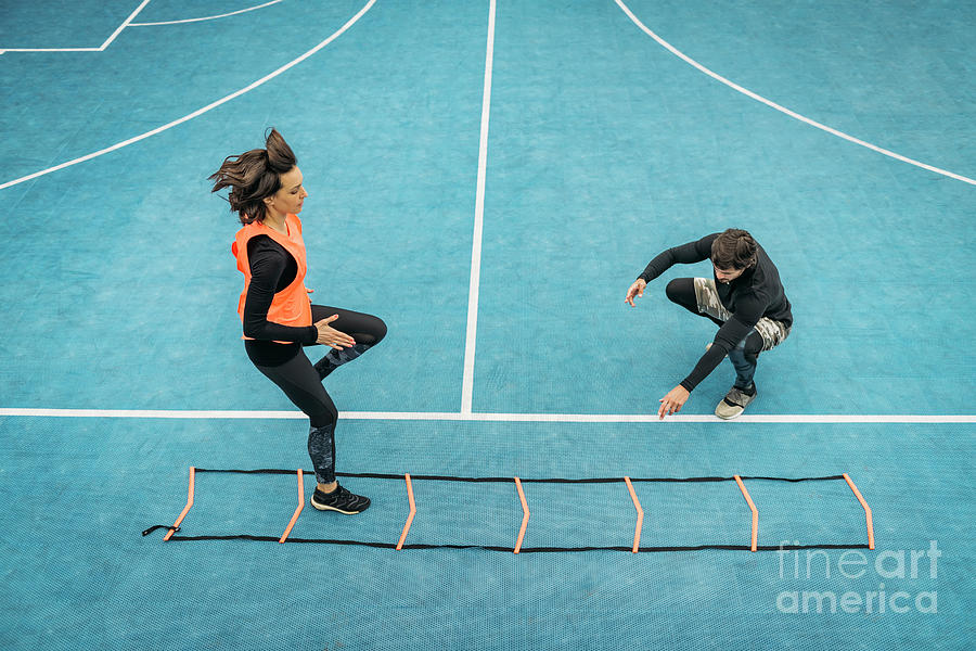 Young Woman Exercising With Agility Ladder #1 Photograph by Microgen Images/science Photo Library