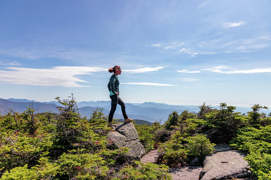 Young Woman Standing At Top Of Mountain Staring Out At Peaks Beyond ...