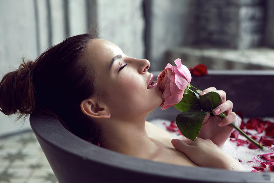 Beautiful Girl Lying In A Stone Bath With Rose Petals And Foam Photograph