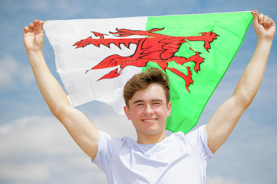 Caucasian male on a beach holding a Welsh flag by Ben Gingell Caucasian male on a beach holding a Welsh flag by Ben Gingell