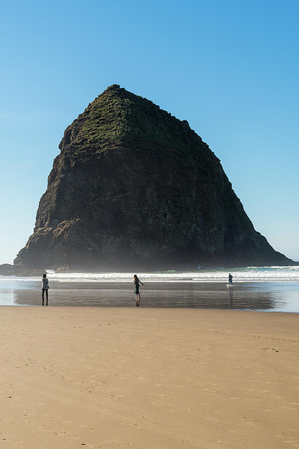 Tourists And Locals Enjoying The Beach With Haystack Rock In Thecannon Beach, Oregon, Usa - October Photograph