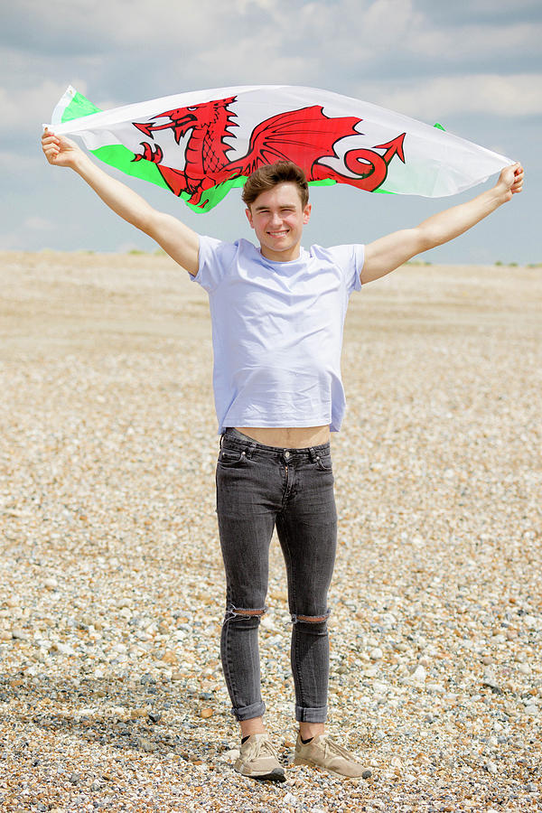 Caucasian male on a beach holding a Welsh flag by Ben Gingell Caucasian male on a beach holding a Welsh flag by Ben Gingell