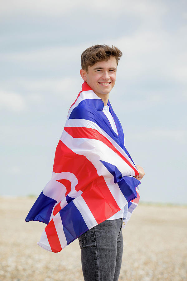Caucasian male on a beach holding a British flag by Ben Gingell Caucasian male on a beach holding a British flag by Ben Gingell