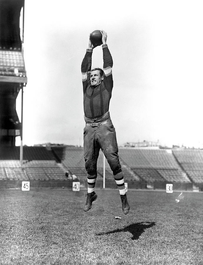 1920s Red Grange Jumping Holding Photograph by Vintage Images