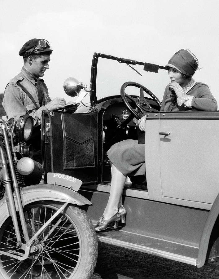 Happy 1920s Dressed Girl Holding Suitcase Next To Vintage Car