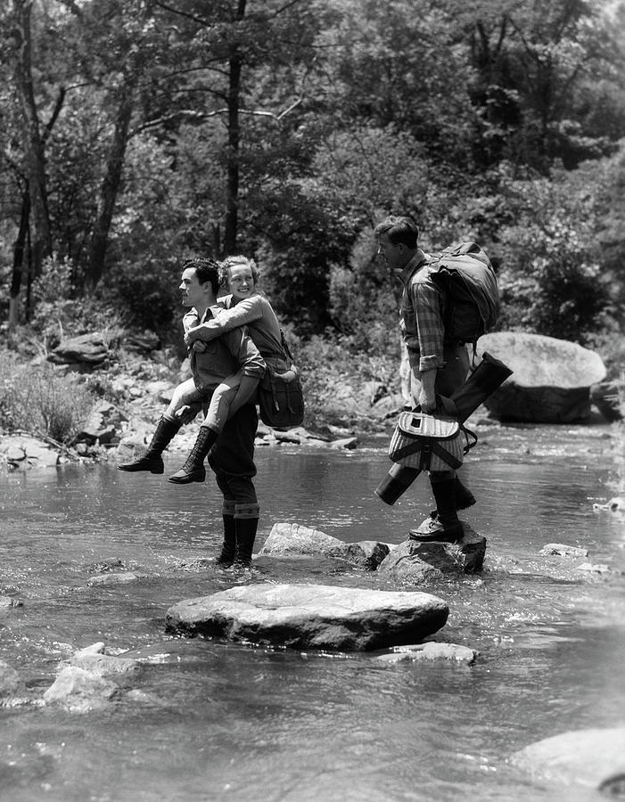 Black And White Painting - 1930s Three People Fording Stream One by Vintage Images