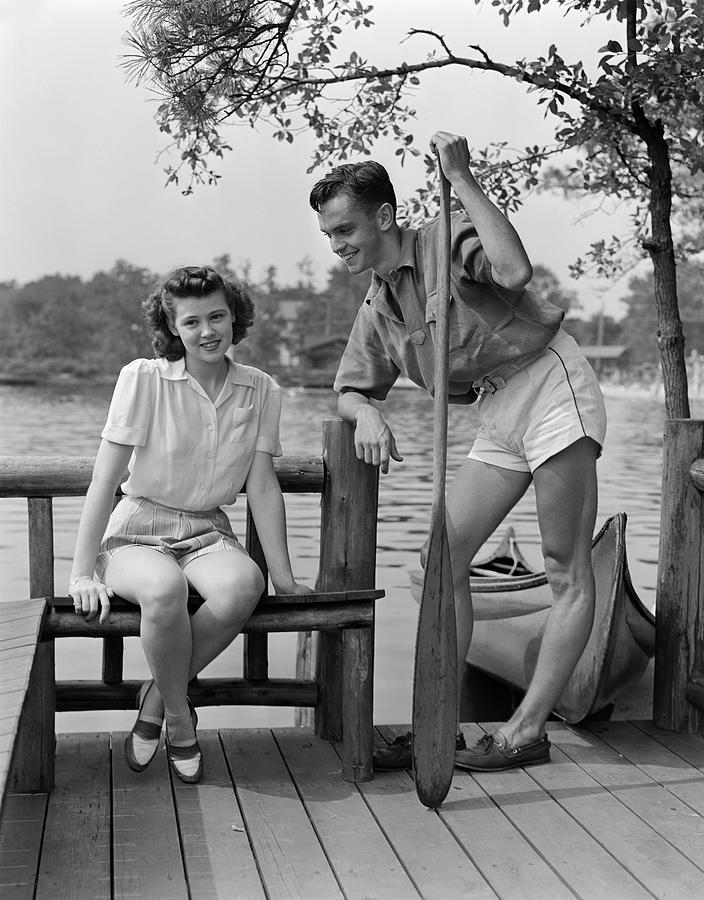 Black And White Photograph - 1940s Teen Couple On Dock By Lake Woman by Vintage Images