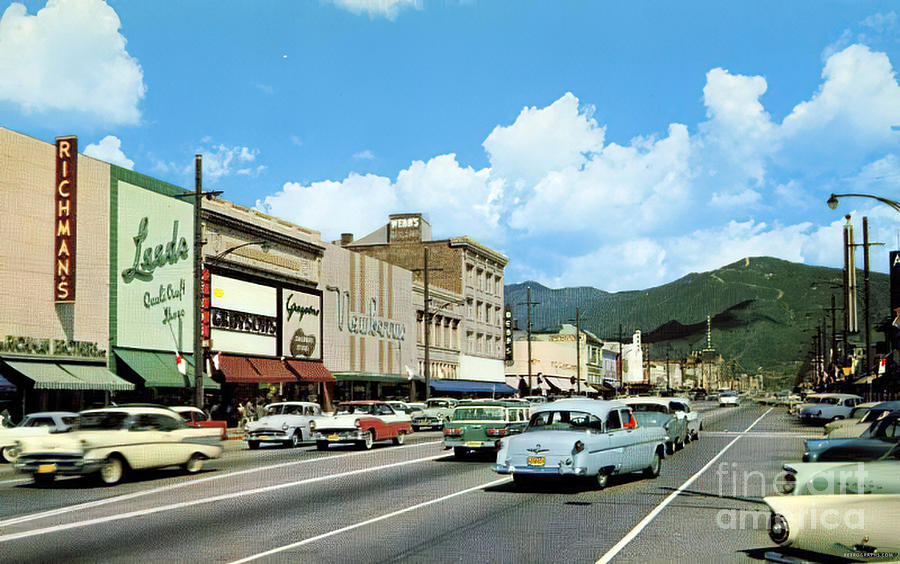 1950s Summer Street Scene Featuring Vintage Cars And Storefronts Photograph by Retrographs
