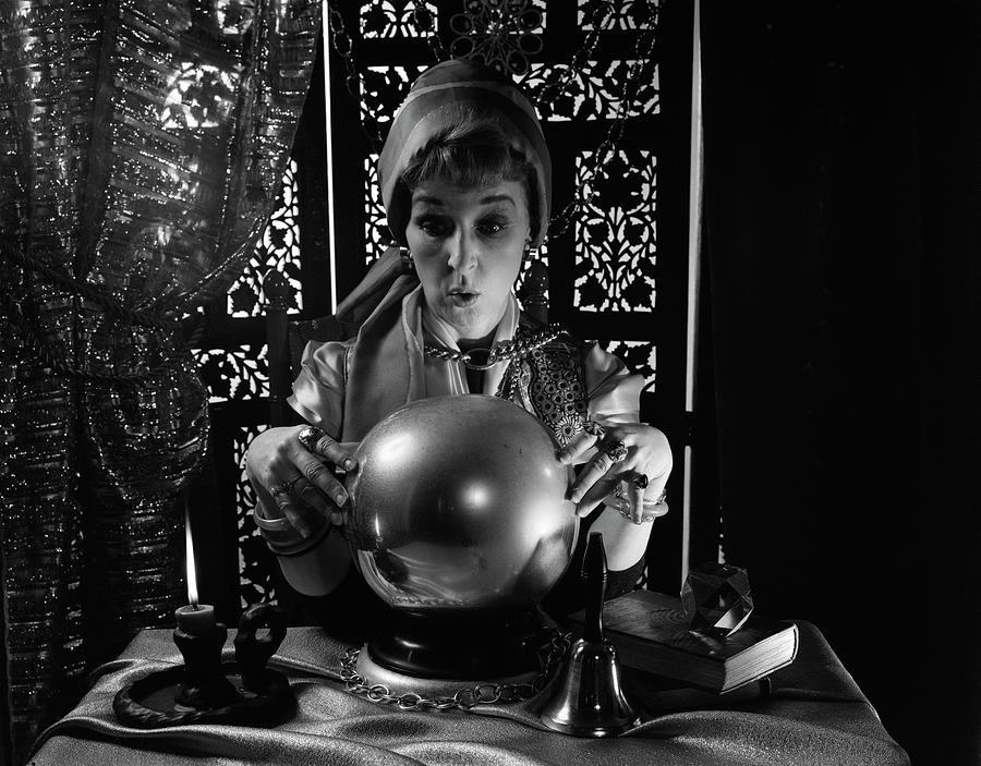Black And White Photograph - 1970s Gypsy Peering Into Crystal Ball by Vintage Images