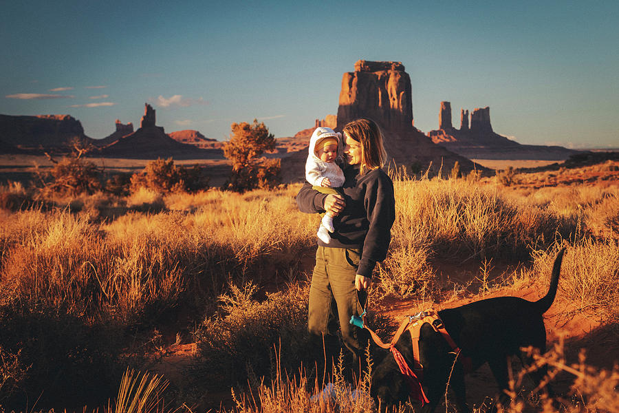 Nature Photograph - A Woman With A Baby And A Dog Is Standing In Monument Valley, Arizona #2 by Cavan Images