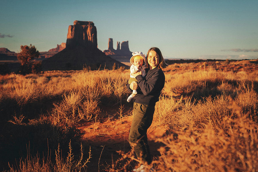Nature Photograph - A Woman With A Baby Is Standing In Monument Valley, Arizona #2 by Cavan Images