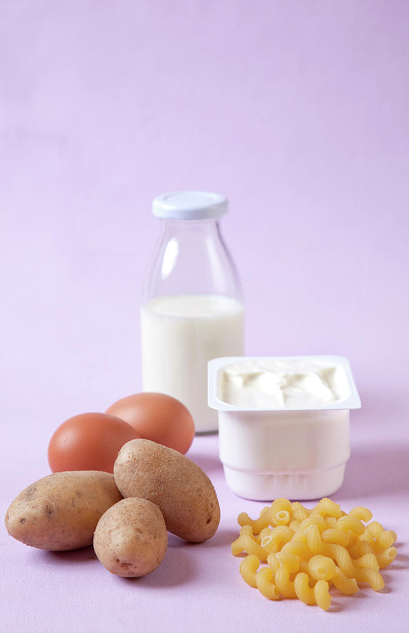 Bottle Of Milk, Egg, Potatoes, Pasta And Butter In Serving Dish Against Pink Background #2 Photograph by Jalag / Annette Falck