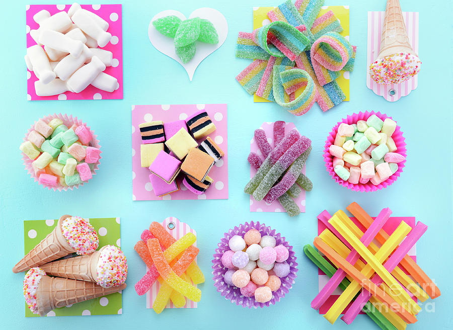 Bright Colorful Candy on Pale Bluw Wood Table.  #2 Photograph by Milleflore Images