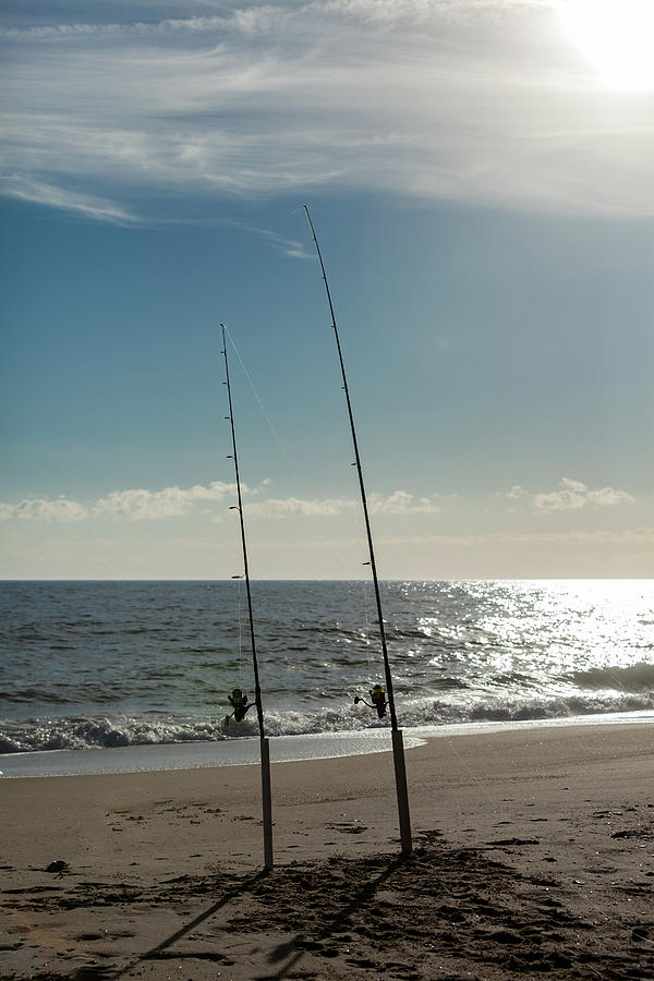 2 Fishing Poles in the sand waiting to play by Terry Thomas