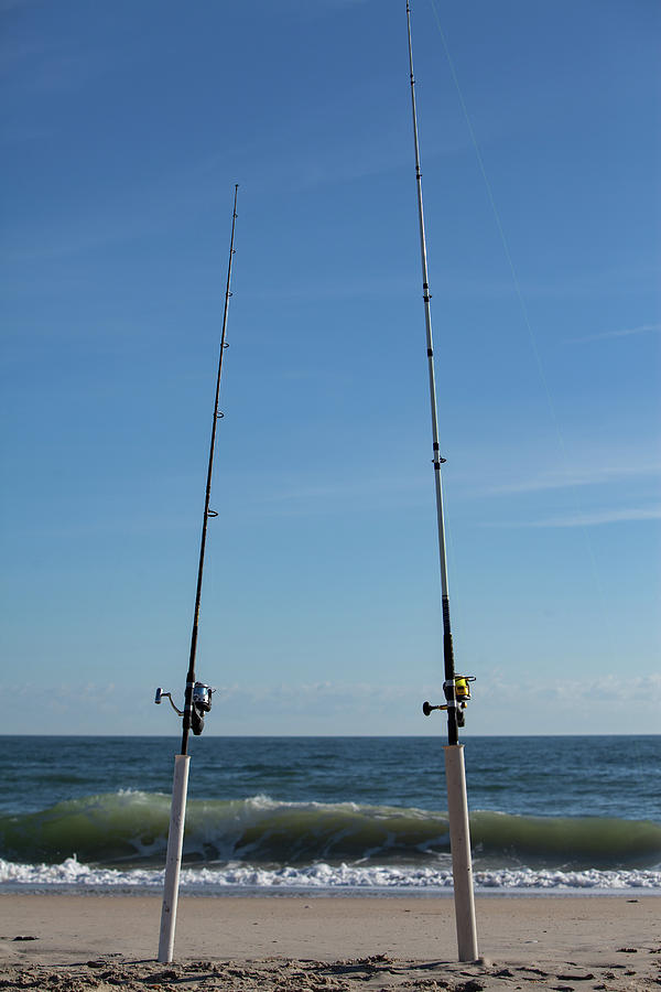 2 Fishing Poles in the standing in the sand by Terry Thomas