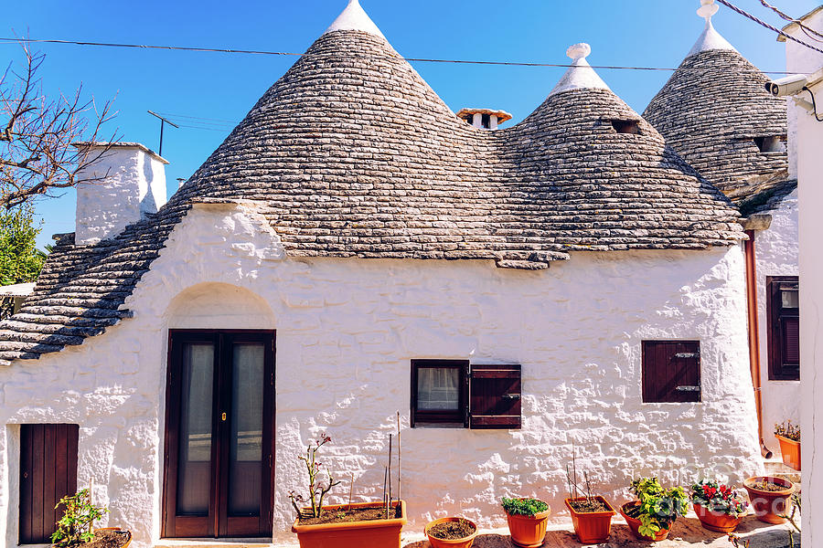Houses of the tourist and famous Italian city of Alberobello, with its typical white walls and trulli conical roofs. #2 Photograph by Joaquin Corbalan