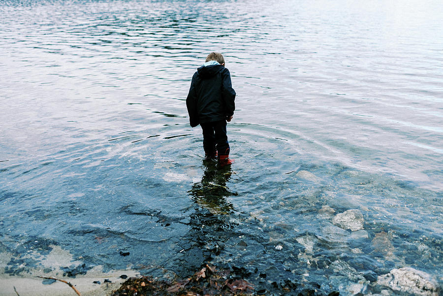 Little Boy In Red Rubber Boots Walking Through Blue Pristine Water ...