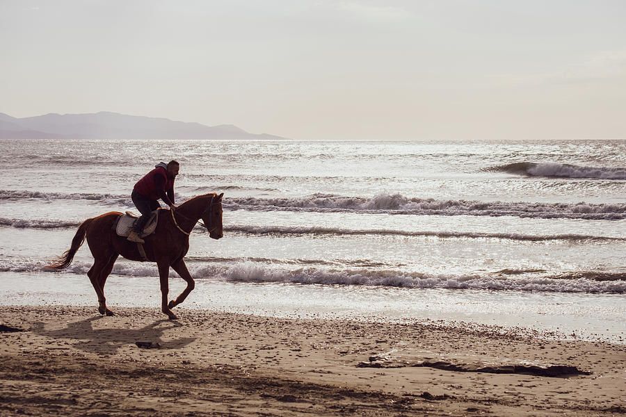 Nature Photograph - Man riding on a brown galloping horse on Ayia Erini beach in Cyp #2 by Iordanis Pallikaras