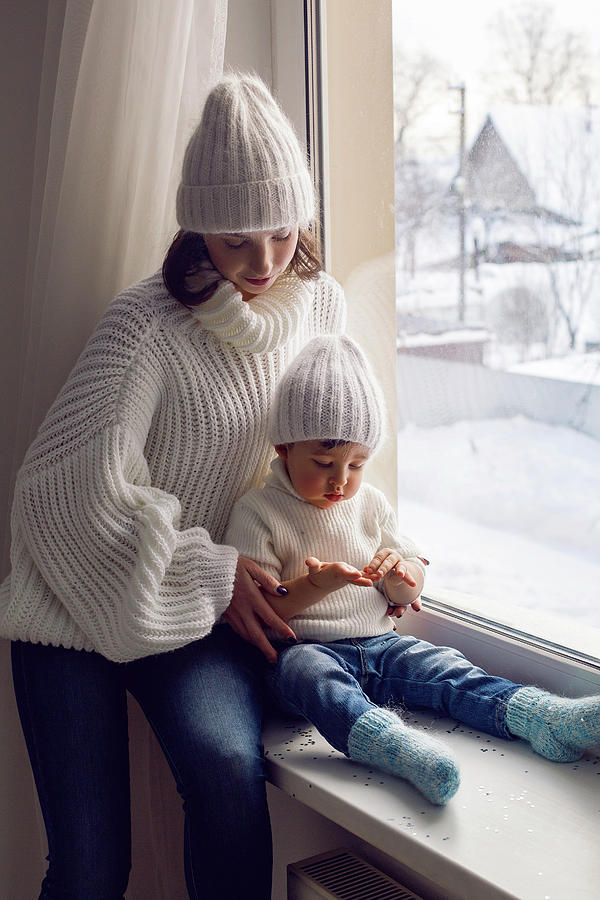 Mom And Son In White Knitted Sweaters And Hats Sitting On The Window Photograph By Elena Saulich