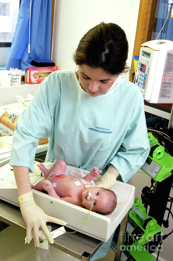 Newborn baby being weighed in a hospital available as Framed Prints,  Photos, Wall Art and Photo Gifts