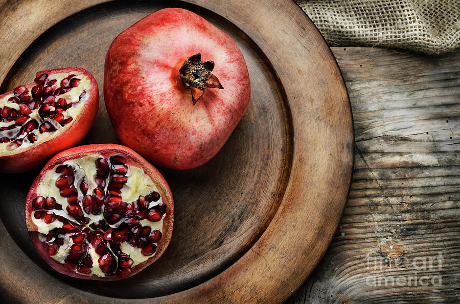 Pomegranate in wooden plate Photograph by Jelena Jovanovic