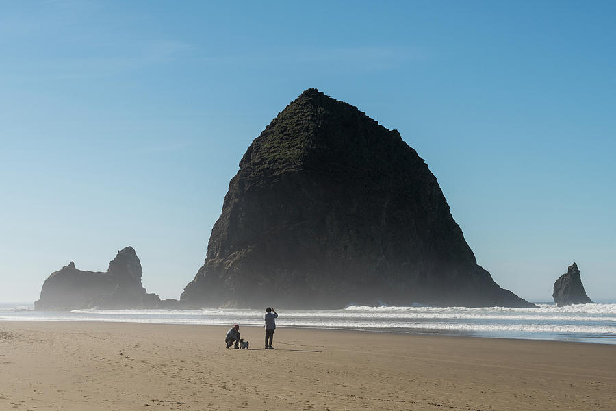 Tourists With A Dog  Enjoying The Beach With Haystack Rock In Thcannon Beach, Oregon, Usa - October Photograph