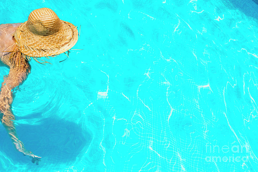 Woman in a pool with hat relaxed and rested. #2 Photograph by Joaquin Corbalan